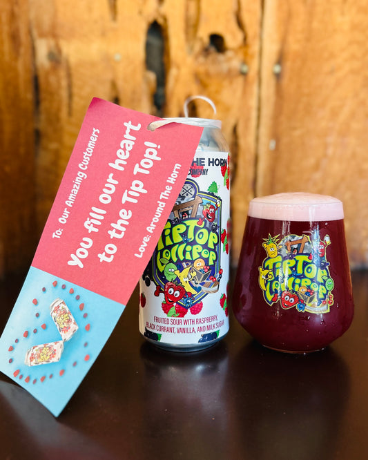 Can and glass of Tip Top Lollipops beer with a promotional card on a wooden surface