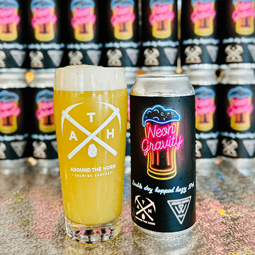 Beer glass and can with 'Around the Horn Brewing Company' branding against a blurred background of similar products.