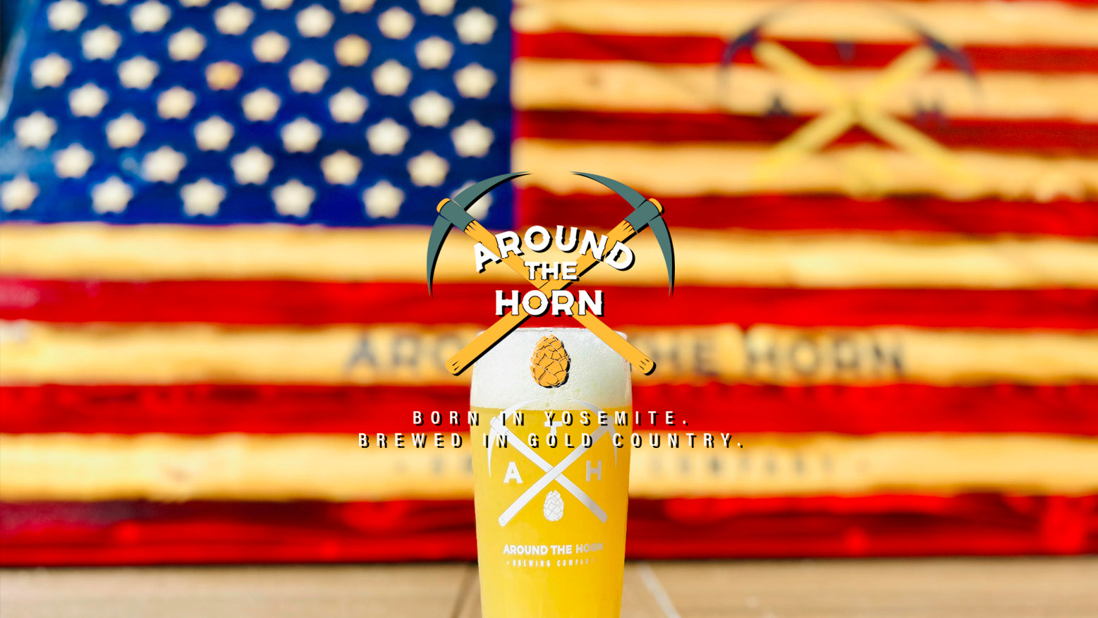 Beer can with 'Around the Horn' branding in front of an American flag and wooden background.