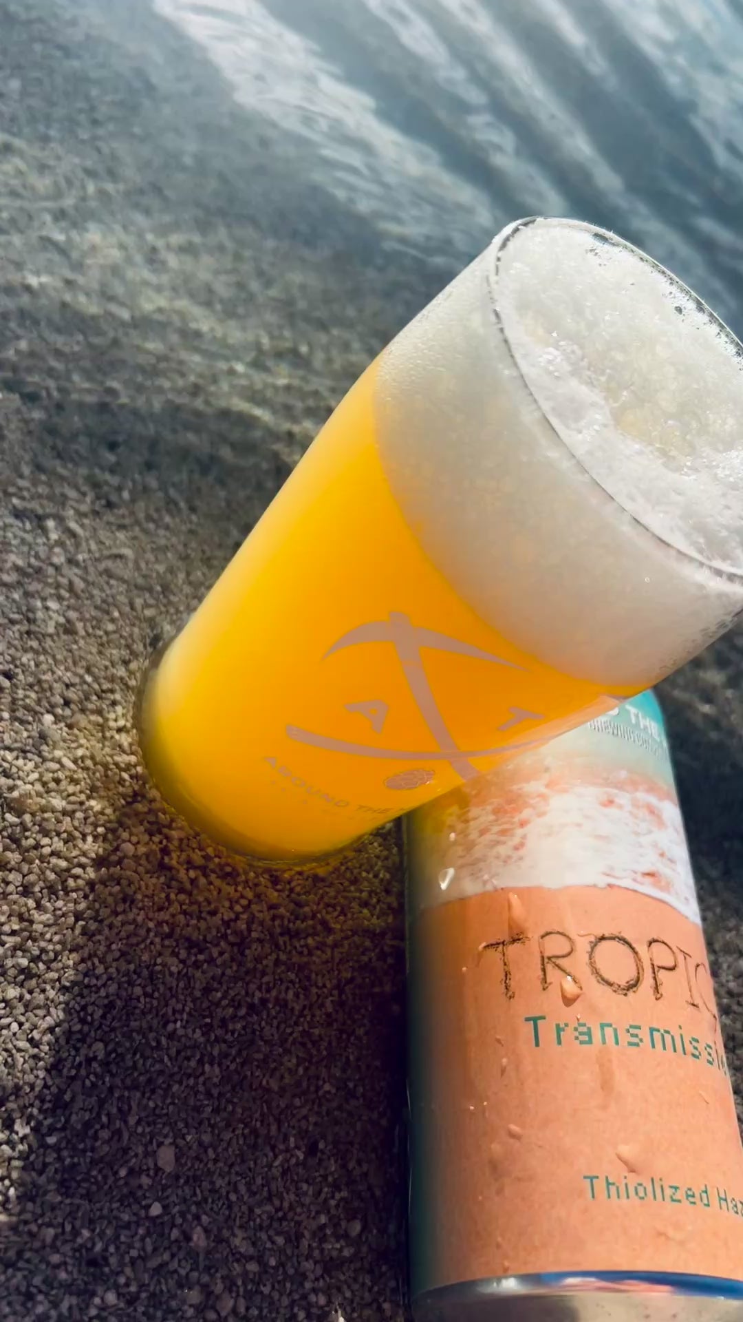 A video showing a can and beer in the sand.